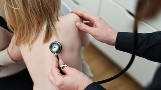 Mit einem Stethoskop untersucht eine Kinderärztin ein Mädchen (Symbolbild)