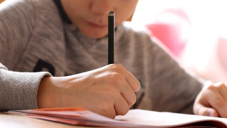 Schüler schreibt in ein Arbeitsheft (Archivbild)
