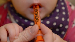 Ein Kind bekommt einen Fiebersaft durch eine Dosierspritze verabreicht (Symbolbild)