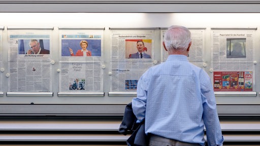Ein Leser studiert die Schlagzeilen im Aushangkasten einer Zeitung (Archivbild)