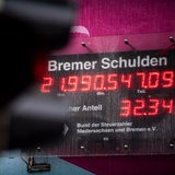 Eine rote Ampel leuchtet vor der Bremer Schuldenuhr (Archivbild)