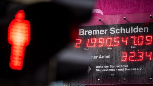 Eine rote Ampel leuchtet vor der Bremer Schuldenuhr (Archivbild)
