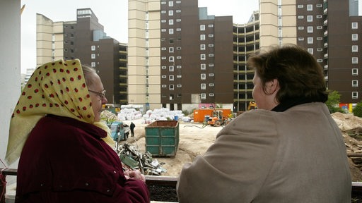 Als Bewohner eines gegenüber gelegenen Hochhauses im Stadtteil Osterholz-Tenever in Bremen, beobachtet Serma Beier (l) zusammen mit ihrer Tochter Valencina  die Abrissarbeiten des riesigen "Kessel-Blocks" in der Neuwieder Straße.