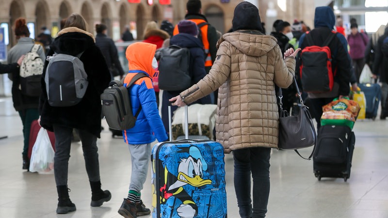 Ukrainische Flüchtlinge im Märt 2022 mit Gepäck an einem Bahnhof in Deutschland (Archivbild)