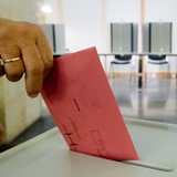 Ein Mann wirft in einem Wahlraum seinen Stimmzettel in eine Wahlurne (Archivbild)