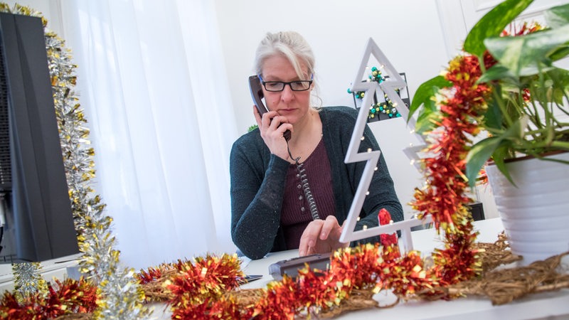 Eine Frau sitzt in einem weihnachtlich dekorierten Büro  Christin Klose