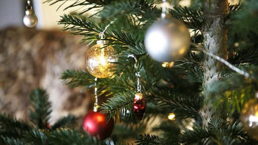 Festlich geschmückter Weihnachtsbaum in einem Wohnzimmer (Symbolbild)
