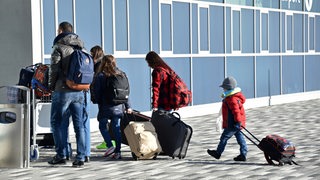Abgelehnte Asylbewerber betreten am 27.11.2015 mit ihrem Gepäck den Terminal des Kassel-Airports in Calden (Hessen). Die sogenannte freiwillige Ausreise führt sie zurück nach Pristina (Kosovo) oder Tirana (Albanien).