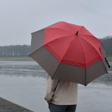 Eine junge Frau steht mit einem Regenschirm auf einem Steg am Werdersee in Bremen