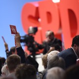 Hände mit Stimmkarten vor SPD-Logo