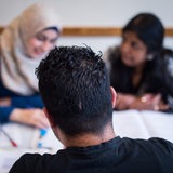 Drei Schüler nehmen in einer Volkshochschule an einem Integrationskurs teil