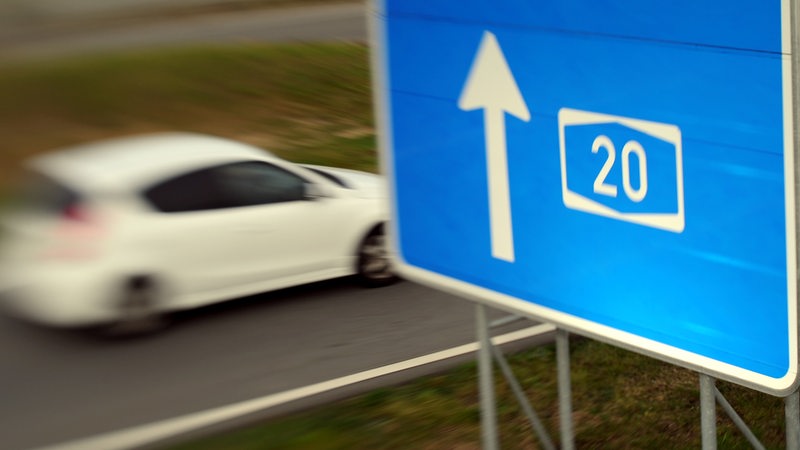 Ein Schild kündigt die Autobahn 20 an. 