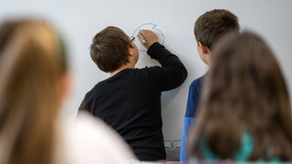 Schüler mit und ohne Behinderung im Unterricht an der Schultafel