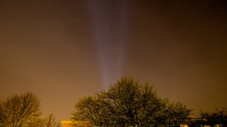 Ein Nachthimmel wird durch Scheinwerfer erleuchtet.