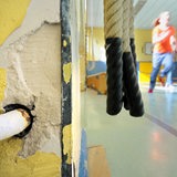 Kinder beim Sportunterricht in einer maroden Halle.