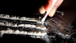 Kokainlinien werden durch einen Geldschein geschnupft