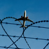 Ein Flugzeug einem Flughafen hinter Stacheldraht