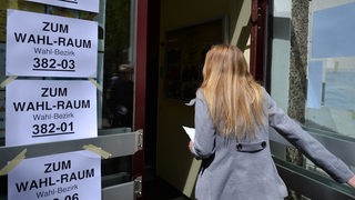 Eine junge Frau betritt ein Bremer Wahllokal