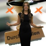 Eine Reporterin steht vor dem Foto eines Stempels.