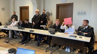 Angeklagte sitzen mit ihren Verteidigern im Landgericht Bremen