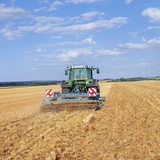 Ein Traktor  fährt über ein Feld.