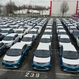 Hunderte verpackte E-Autos stehen auf einem Parkplatz