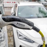 Ein Auto wird an einer Ladesäule aufgeladen.