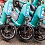 Mehrere E-Scooter der marke "Dott" stehen nebeneinander.