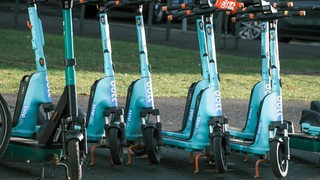 Mehrere E-Scooter der Marke "Dott" stehen nebeneinander.