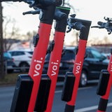 E-Scooter der Marke "Voi" stehen nebeneinander im öffentlichen Raum (Archivbild)
