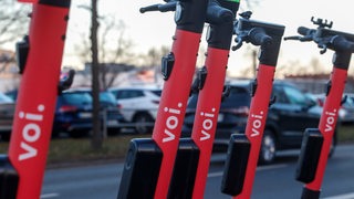 E-Scooter der Marke "Voi" stehen nebeneinander im öffentlichen Raum (Archivbild)