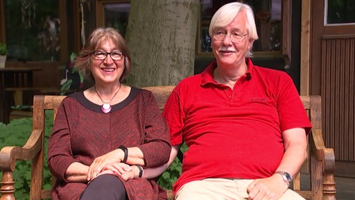 Die Eheleute Böhk auf einer Gartenbank. Sie lächeln beide.