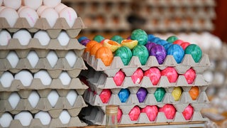 Eier liegen in Kartons bereit. Einge davon sind bunt angemalt.