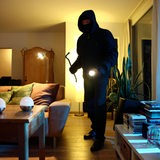 Ein Einbrecher dringt in Wohnung ein, durchsucht die Räume nach Wertgegenständen