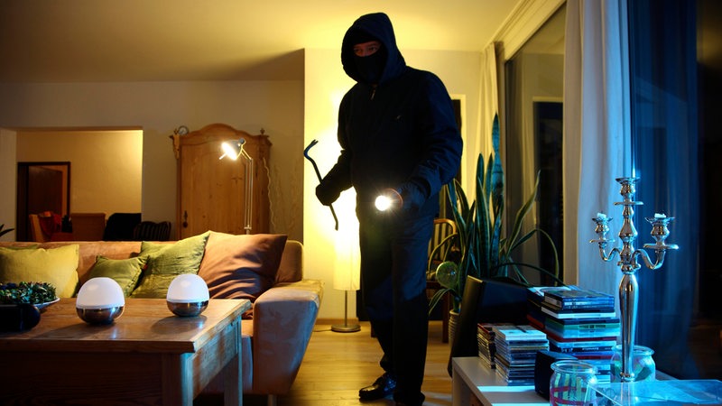 Ein Einbrecher dringt in Wohnung ein, durchsucht die Räume nach Wertgegenständen