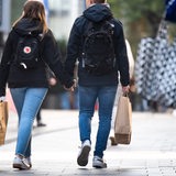 Passanten mit Einkaufstüten laufen durch die Innenstadt.