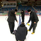 Mehrere Männer arbeiten an der Eisfläche in der Eisarena.
