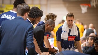 Die Spieler der Eisbären Bremerhaven stehen während einer Auszeit nebeneinander. Coach Key gibt in der Mitte Anweisungen.