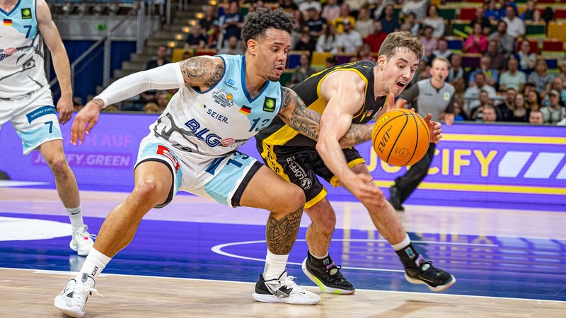 Ein Spieler der Eisbären Bremerhaven und der Tübingen Tigers kämpfen um den Ball.