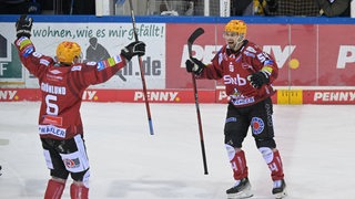 Eishockey-Spieler der Fischtown Pinguins reißen die Arme hoch und bejubeln einen Treffer.