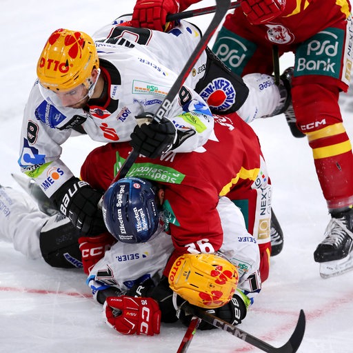 Eishockey-Spieler der Fischtown Pinguins auf dem Eis aufeinander Spielern der Düsseldorfer EG wie ein Sandwich.