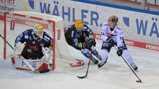 Eishockey-Profi Christian Wejse von den Fischtown Pinguins verteidigt das Bremerhavener Tor gegen einen Ingoldstädter Spieler.