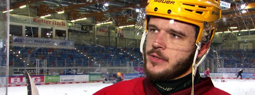 Eishockey-Profi Lukas Kälble von den Fischtown Pinguins steht am Rande der Eisfläche bei einem Interview.