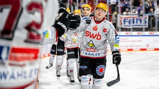 Eishockey-Spieler Ross Mauermann von den Fischtown Pinguins klatscht nach dem Spiel auf dem Eis die gegnerischen Spieler ab.