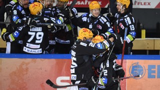 Eishockey-Spieler der Fischtwon Pinguins liegen sich nach einem Treffer in den Play-offs jubelnd in den Armen.