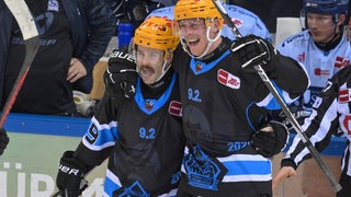 Die Eishockey-Spieler Colt Conrad und Nicholas Jensen von den Fischtown Pinguins bejubeln gemeinsam den Treffer gegen Straubing.
