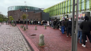 Viele Menschen stehen in einer langen Schlange vor der Eisarena Bremerhaven an für Finaltickets der Fischtown Pinguins.