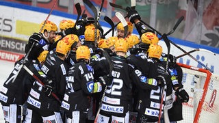 Eishockey-Spieler der Fischtown Pinguins Bremerhaven kommen zur Jubel-Traube zusammen nach ihrem Finaleinzug.