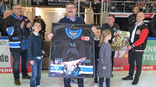 Alfred Prey, Manager des Eishockey-Klubs Fischtown Pinguins, bekommt in der Eisarena zu seinem 70. Geburtstag ein besonderes Trikot überreicht.