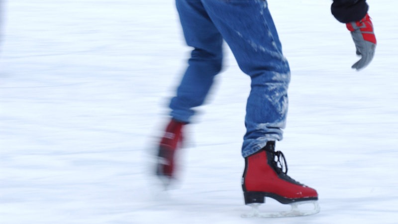 Ein Schlittschuhläufer auf einer Eisfläche.